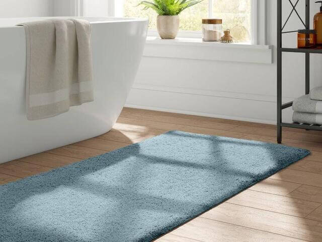Una alfombra decora el suelo de un cuarto de baño